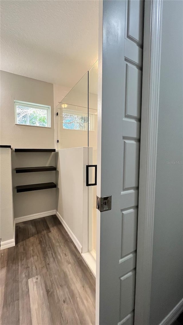 bathroom with a textured ceiling and hardwood / wood-style floors