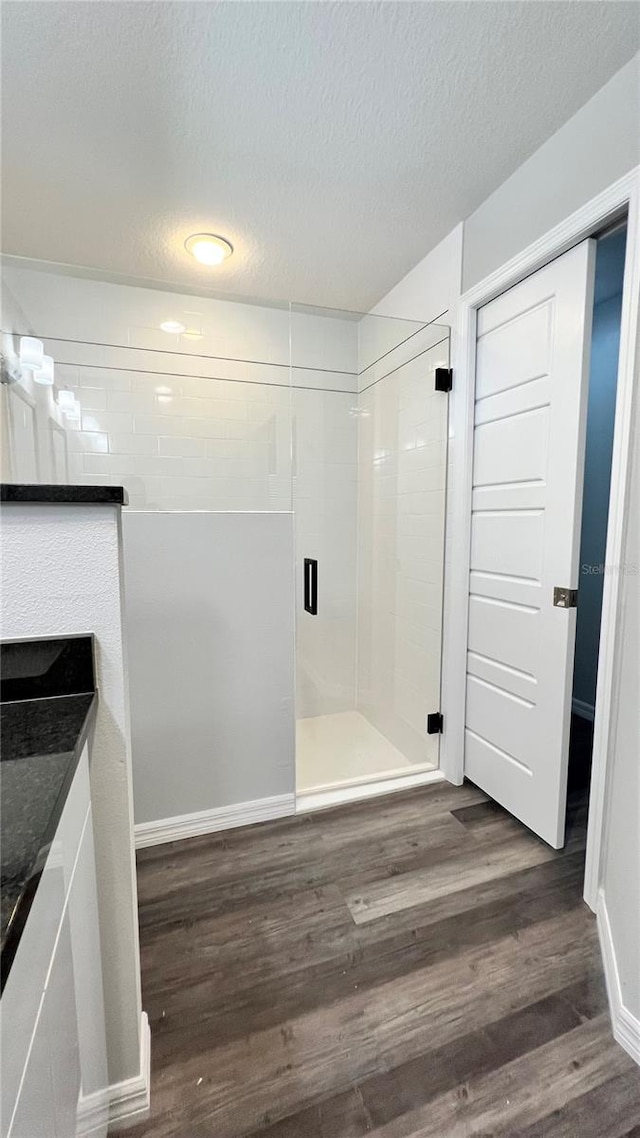 interior space with tiled shower, hardwood / wood-style flooring, and a textured ceiling