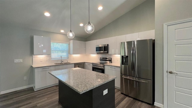 kitchen featuring decorative light fixtures, dark hardwood / wood-style floors, a kitchen island, tasteful backsplash, and appliances with stainless steel finishes