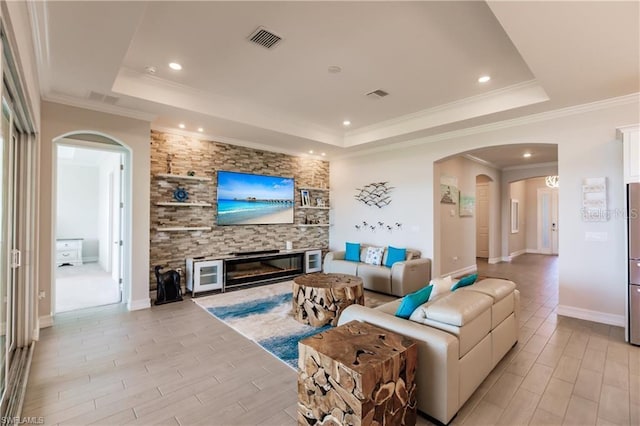 living room featuring a raised ceiling and crown molding