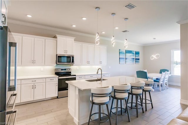 kitchen featuring appliances with stainless steel finishes, white cabinets, sink, and tasteful backsplash