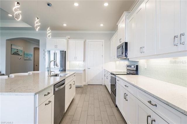 kitchen featuring sink, white cabinets, tasteful backsplash, and appliances with stainless steel finishes