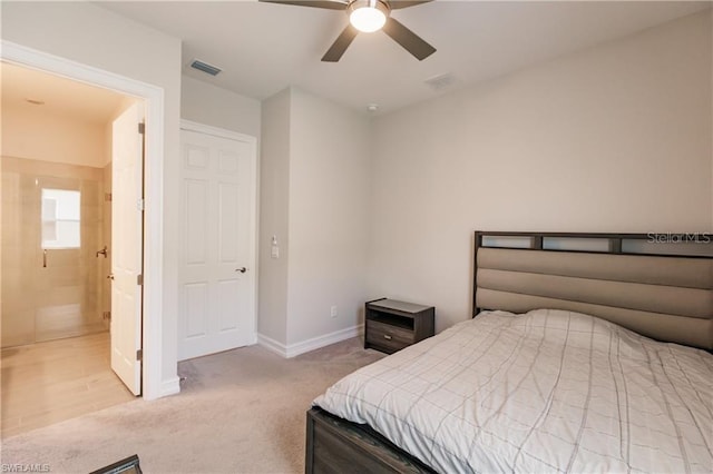 carpeted bedroom with ceiling fan and ensuite bath