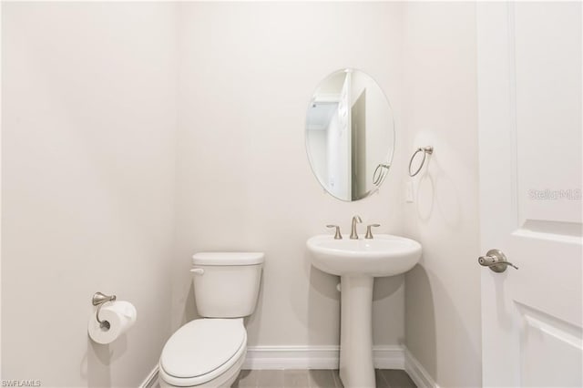 bathroom featuring tile floors and toilet