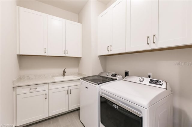 laundry area featuring separate washer and dryer, cabinets, light hardwood / wood-style flooring, hookup for an electric dryer, and sink