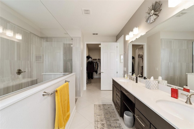 bathroom with tile patterned floors, vanity, and a shower