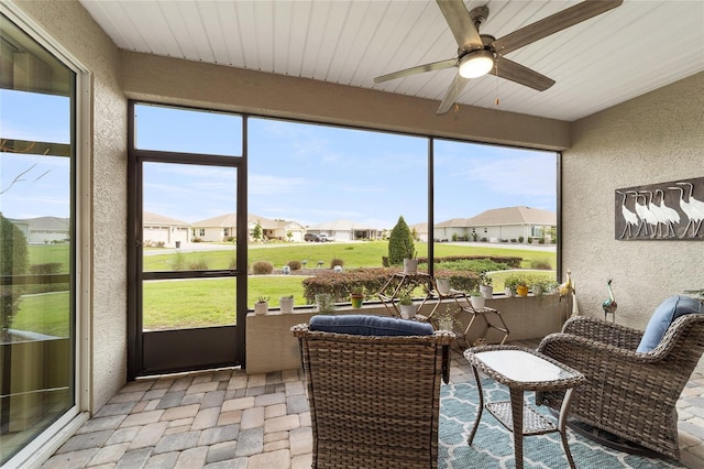 sunroom / solarium with ceiling fan, a healthy amount of sunlight, and wooden ceiling