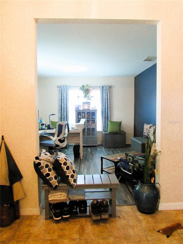 living room featuring baseboards, visible vents, and tile patterned floors