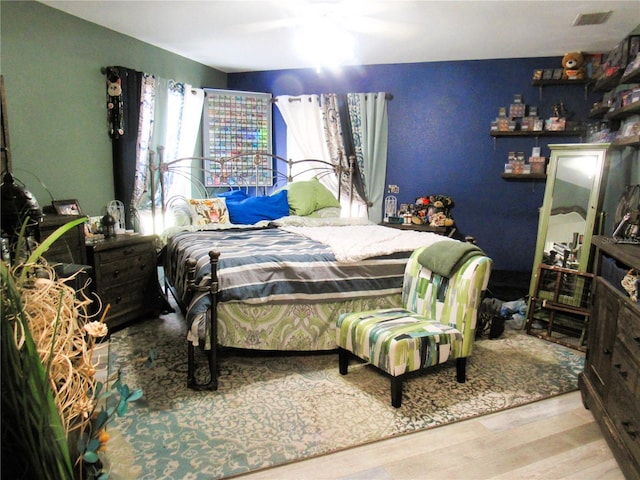 bedroom featuring wood finished floors and visible vents