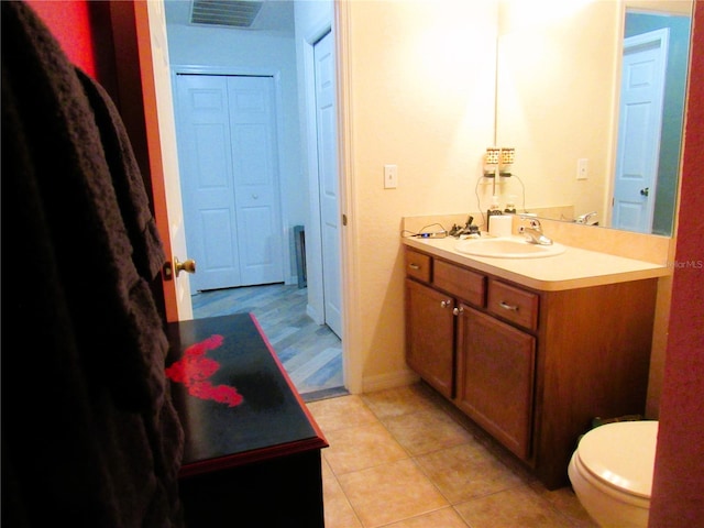 bathroom featuring visible vents, baseboards, toilet, tile patterned flooring, and vanity