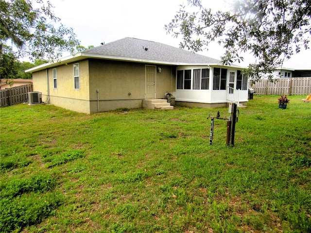 back of house featuring cooling unit, a sunroom, a yard, and fence private yard