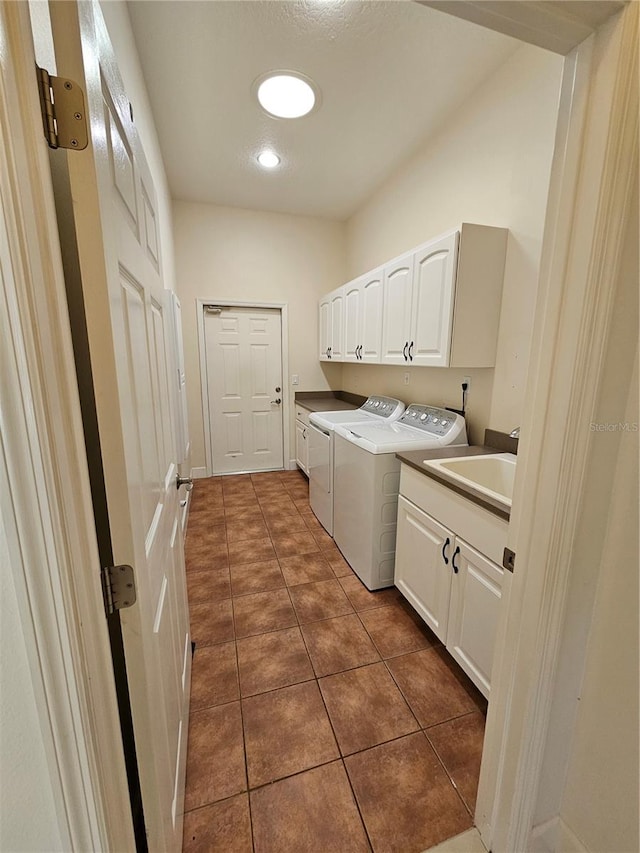 laundry area featuring sink, cabinets, separate washer and dryer, and dark tile floors