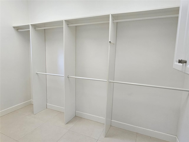 walk in closet with light tile flooring