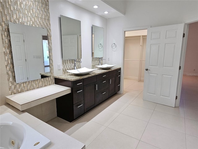 bathroom with tiled bath, double sink vanity, and tile floors