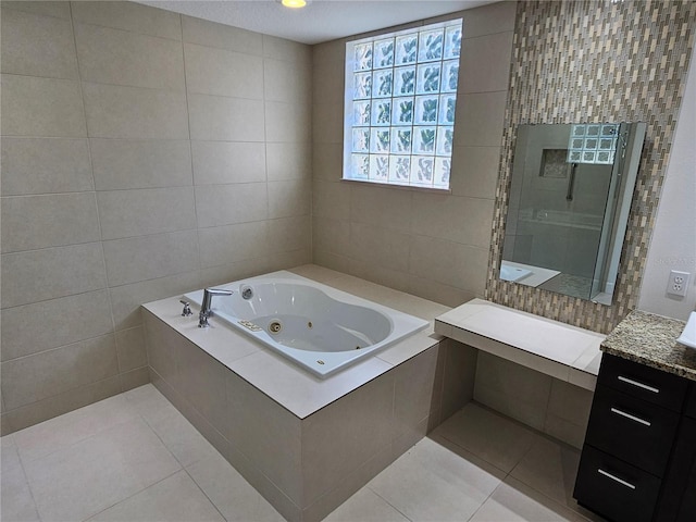 bathroom featuring tile walls, tile flooring, a relaxing tiled bath, and vanity