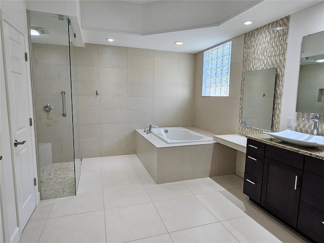 bathroom featuring independent shower and bath, vanity, tile walls, and tile floors