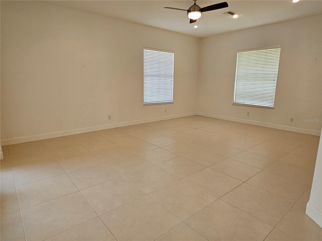 tiled spare room featuring ceiling fan