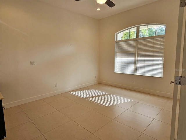 tiled spare room featuring ceiling fan