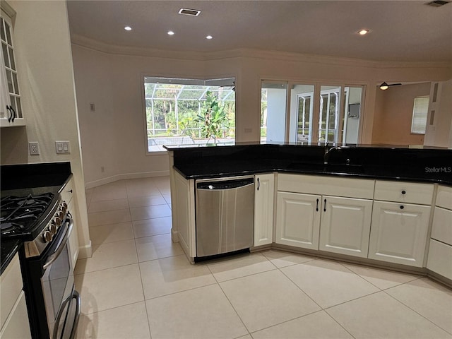 kitchen with ornamental molding, light tile floors, white cabinetry, and appliances with stainless steel finishes