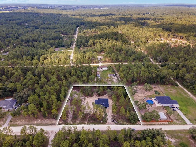 birds eye view of property featuring a wooded view