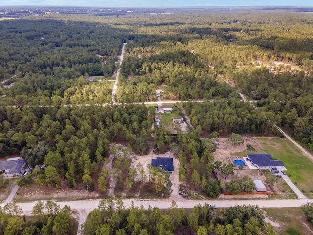 bird's eye view with a wooded view