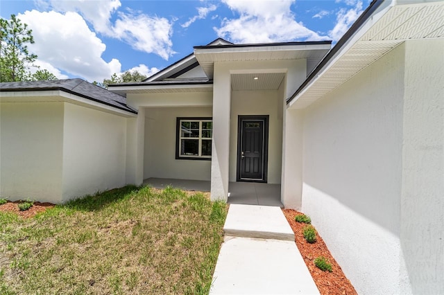 view of exterior entry with stucco siding