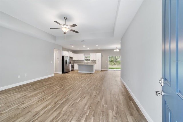 unfurnished living room with ceiling fan, recessed lighting, light wood-style flooring, and baseboards