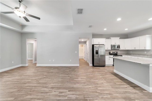 kitchen featuring visible vents, appliances with stainless steel finishes, open floor plan, white cabinetry, and baseboards