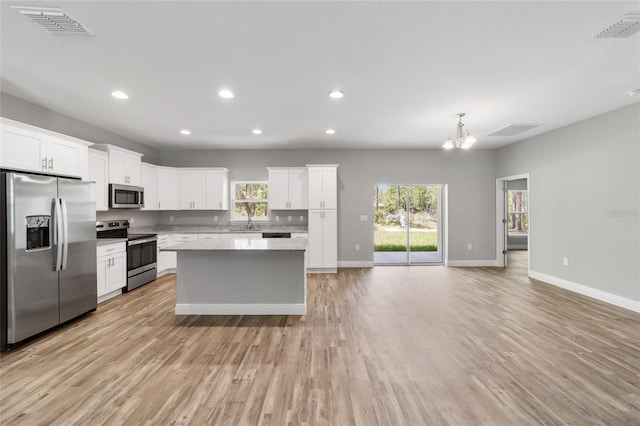 kitchen featuring appliances with stainless steel finishes, a center island, and visible vents