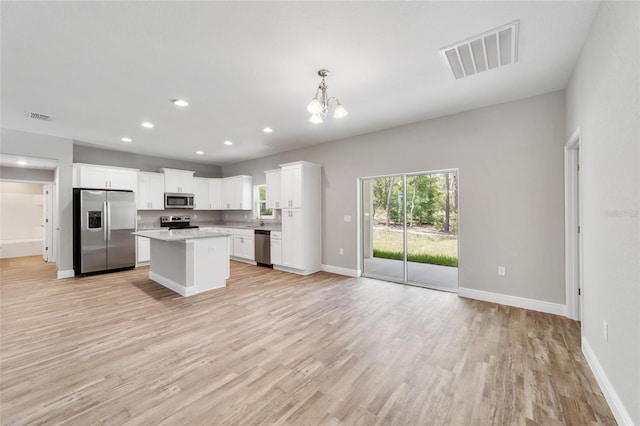 kitchen featuring visible vents, appliances with stainless steel finishes, open floor plan, and light wood-style flooring