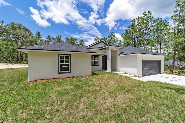 view of front of house with an attached garage, a front lawn, concrete driveway, and stucco siding