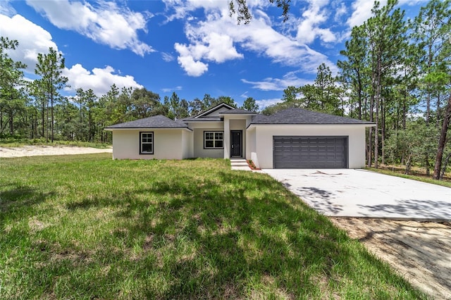 view of front of house with a front yard, driveway, an attached garage, and stucco siding