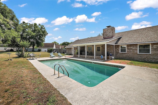 view of swimming pool featuring a lawn and a patio area