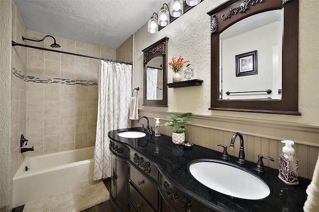 bathroom with shower / bath combo with shower curtain, vanity, and a textured ceiling