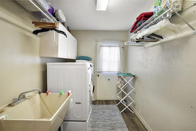 laundry area with dark hardwood / wood-style flooring, washer and dryer, cabinets, and sink