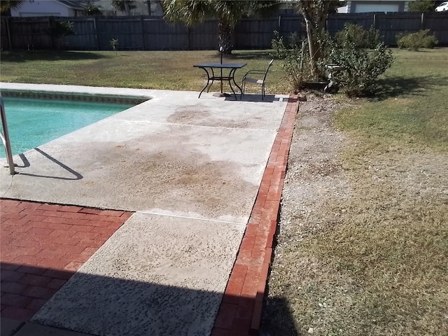 view of swimming pool with a patio area and a yard