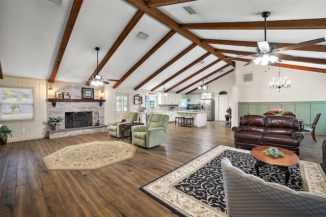 living room with a fireplace, ceiling fan with notable chandelier, lofted ceiling with beams, and dark hardwood / wood-style floors