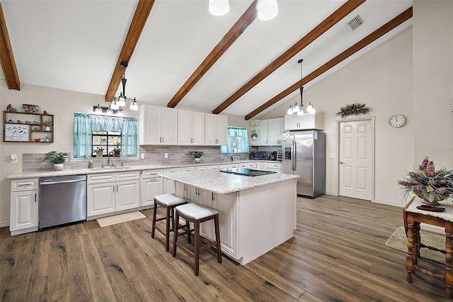 kitchen featuring a center island, sink, hanging light fixtures, appliances with stainless steel finishes, and white cabinetry