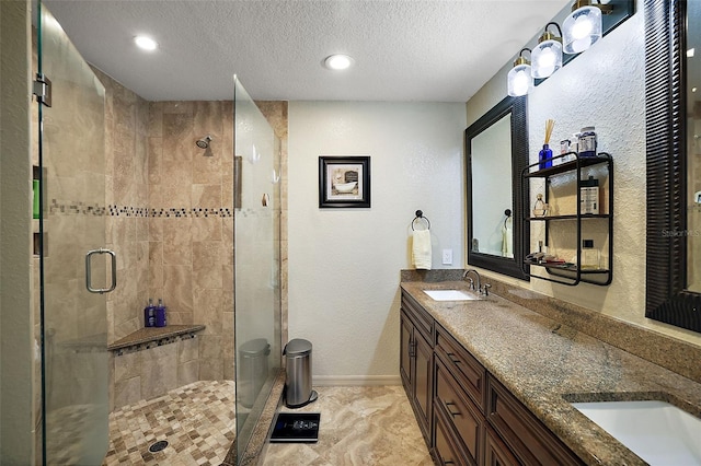 bathroom with vanity, a textured ceiling, and walk in shower