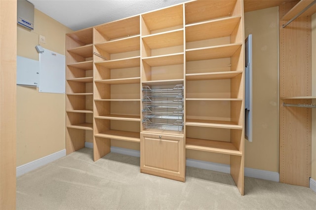 spacious closet with a wall mounted AC and light colored carpet