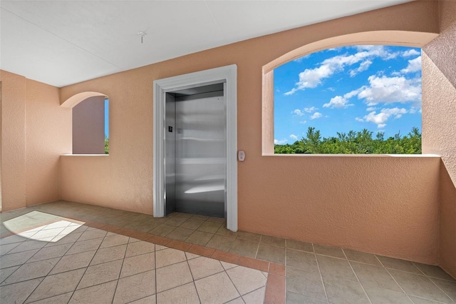 entrance to property with elevator and a balcony