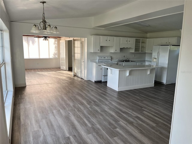 kitchen featuring hanging light fixtures, a notable chandelier, lofted ceiling, white appliances, and a kitchen island