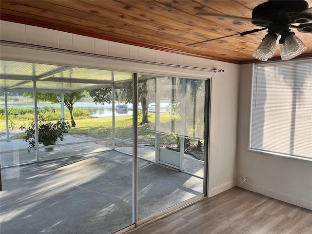 doorway to outside with a healthy amount of sunlight, a water view, wooden ceiling, and ceiling fan