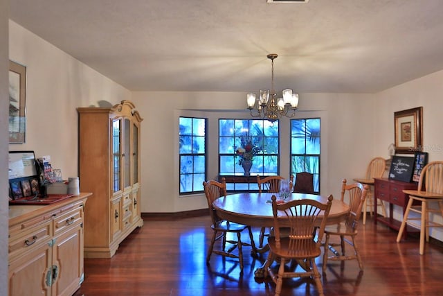 dining room with dark wood-type flooring and a notable chandelier