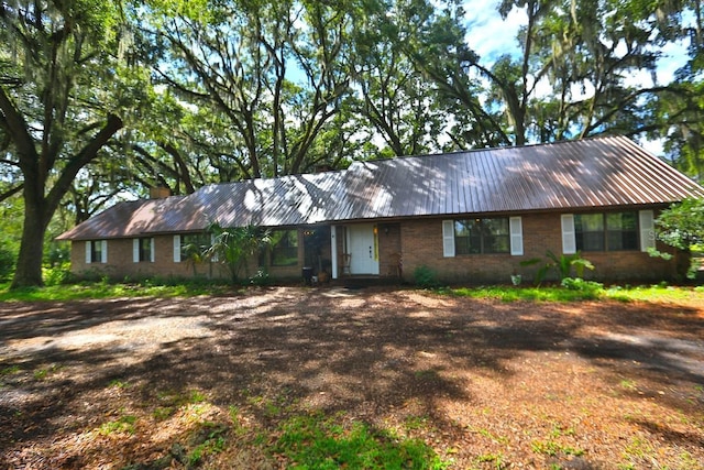18001 SE Hawthorne Rd, Hawthorne, FL 32640 - ranch-style home featuring brick siding, dirt driveway, a chimney, and metal roof