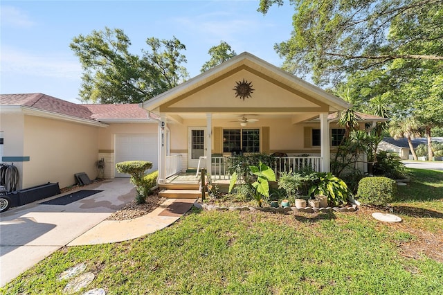 view of front of property with covered porch, a garage, driveway, stucco siding, and a front yard