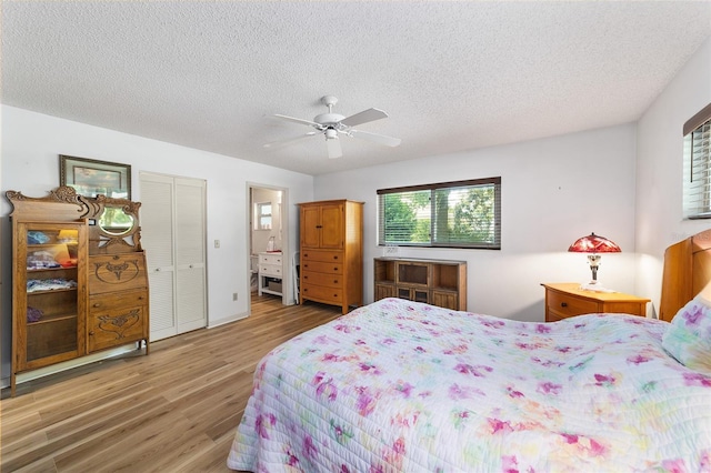 bedroom with ensuite bath, hardwood / wood-style flooring, ceiling fan, a textured ceiling, and a closet