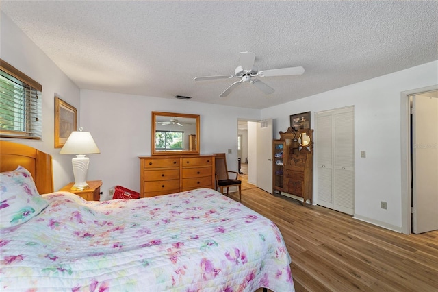 bedroom featuring a closet, a textured ceiling, hardwood / wood-style flooring, and ceiling fan