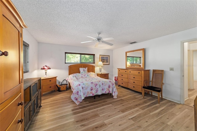 bedroom featuring light hardwood / wood-style flooring, multiple windows, and ceiling fan