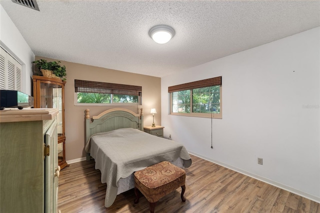 bedroom with wood-type flooring and a textured ceiling